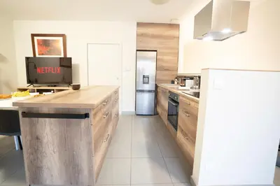 a kitchen with wooden cabinets and a refrigerator at Air-conditioned 2 bedroom apartment with Terrace Parking Carcassonne in Carcassonne