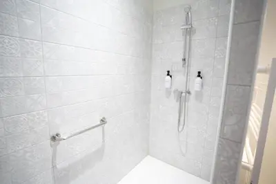 a bathroom with a shower with white tiles at Air-conditioned 2 bedroom apartment with Terrace Parking Carcassonne in Carcassonne