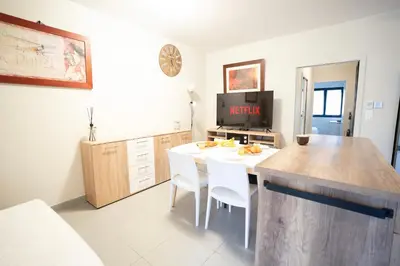 a kitchen with a white table and white chairs at Air-conditioned 2 bedroom apartment with Terrace Parking Carcassonne in Carcassonne