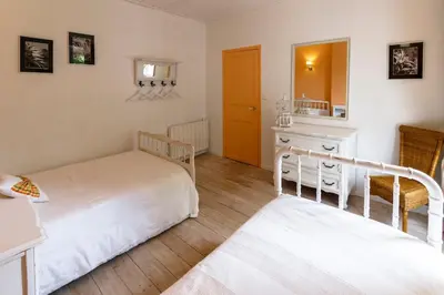 a bedroom with two beds and a mirror at Le Vieux Tilleul - Maison de vacances in Ferrals-lès-Corbières