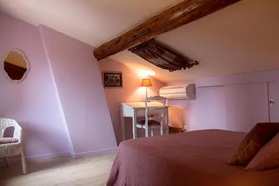 a bedroom with a bed and a table with a lamp at Le Vieux Tilleul - Maison de vacances in Ferrals-lès-Corbières
