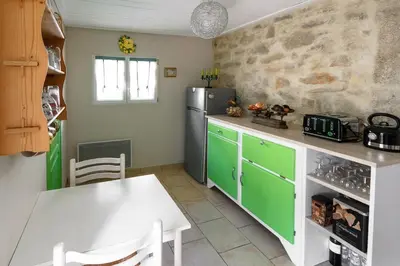 a kitchen with a white table and a refrigerator at Le Vieux Tilleul - Maison de vacances in Ferrals-lès-Corbières