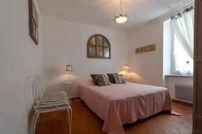 a bedroom with a bed and a chair and a window at Le Vieux Tilleul - Maison de vacances in Ferrals-lès-Corbières