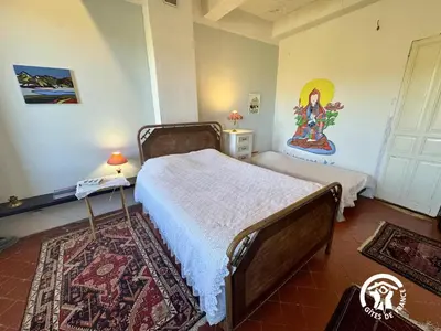 a bedroom with a bed and a painting on the wall at La maison in Davejean