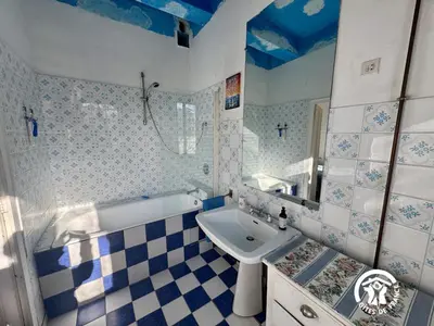 a blue and white bathroom with a sink and a tub at La maison in Davejean