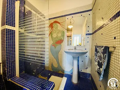 a bathroom with a mermaid mural on the wall at La maison in Davejean
