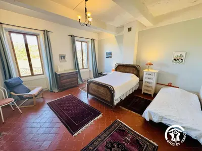 a bedroom with two beds and a chair in it at La maison in Davejean