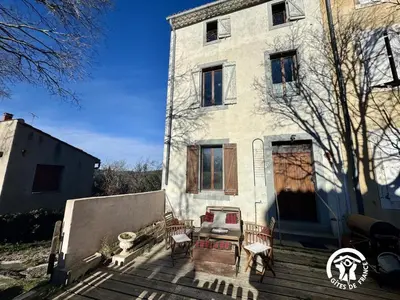 a white house with some chairs on the stairs at La maison in Davejean