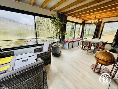 a living room with a table and chairs and windows at Grand sissou in Bugarach