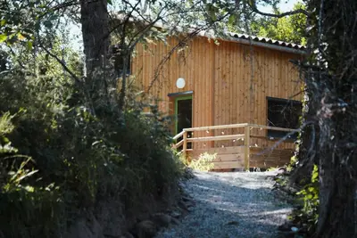 a wooden cabin with a porch in the woods at Les Gîtes de Montbel, nestled in nature in Montbel