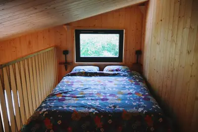 a bed in a small room with a window at Les Gîtes de Montbel, nestled in nature in Montbel