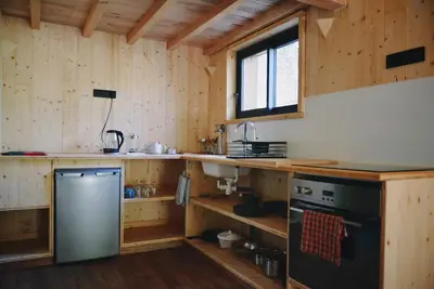 a kitchen with wooden walls and a stove and a sink at Les Gîtes de Montbel, nestled in nature in Montbel