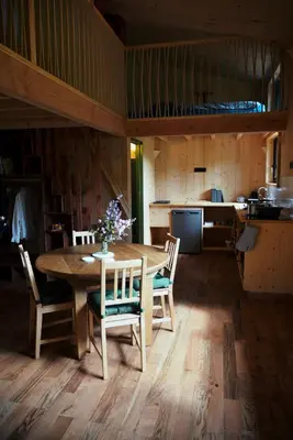 a dining room with a table and chairs and a kitchen at Les Gîtes de Montbel, nestled in nature in Montbel