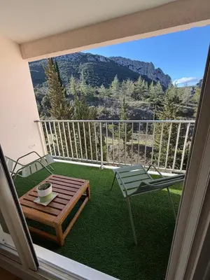 a balcony with a table and a chair and a view at Regard du planteur d'arbres in Saint-Paul-de-Fenouillet