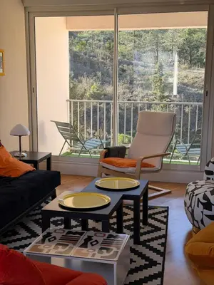 a living room with two tables and a large window at Regard du planteur d'arbres in Saint-Paul-de-Fenouillet