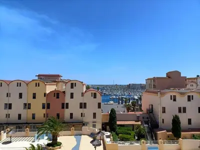 a view of a city with buildings and a harbor at Appartement charmant avec balcon, piscine - 5 pers. - FR-1-619-159 in Gruissan