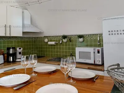 a table with plates and wine glasses on it at Appartement charmant avec balcon, piscine - 5 pers. - FR-1-619-159 in Gruissan