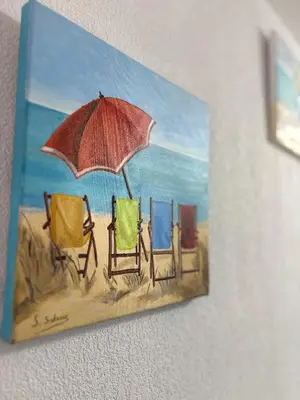 a painting of chairs on a beach with an umbrella at Clos des pins- Climatisation-Parking-Draps By LCG in Gruissan