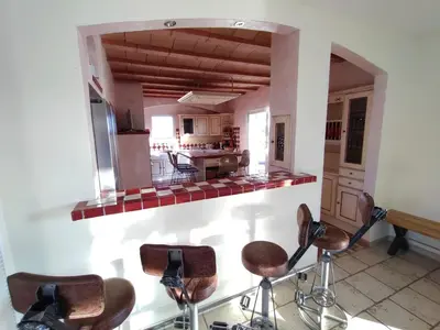 a kitchen with a mirror and stools in a room at Hacienda Del Sol, beautiful villa with pool in Sigean
