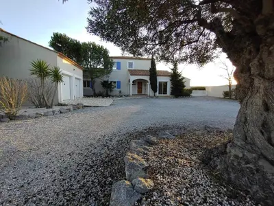 a house with a tree in front of a driveway at Hacienda Del Sol, beautiful villa with pool in Sigean