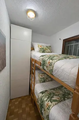 a small room with two beds and a closet at Charmant appartement proche du port in Gruissan