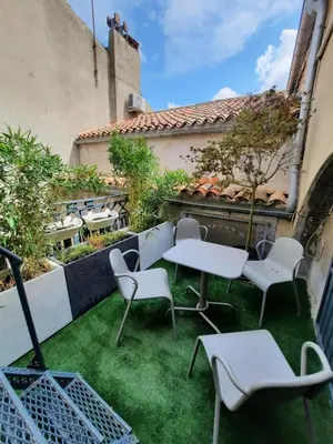 a patio with tables and chairs on the grass at Aviator in Carcassonne