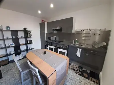 a kitchen with a wooden table and a sink at Aviator in Carcassonne