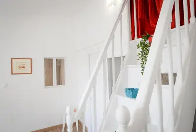 a white staircase with a plant in a window at Aviator in Carcassonne