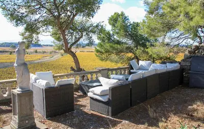 a group of chairs and a statue in a yard at Maison Avec Piscine Et Jacuzzi in Rieux-Minervois