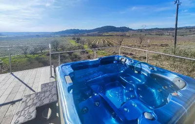a jacuzzi tub with a view of a field at Maison Avec Piscine Et Jacuzzi in Rieux-Minervois
