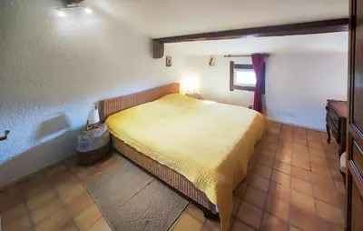 a bedroom with a yellow bed in a room at Maison Avec Piscine Et Jacuzzi in Rieux-Minervois