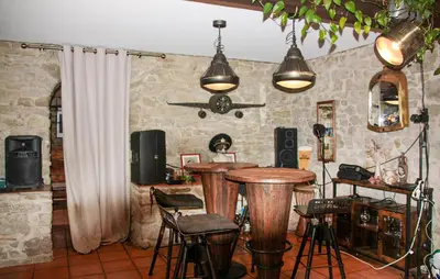 a room with two bar stools and a table in it at Maison Avec Piscine Et Jacuzzi in Rieux-Minervois