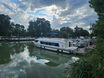 a group of boats docked at a dock on a river at NAVYLIS Croisière in Capestang