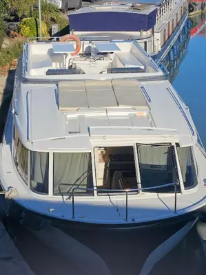 a white boat is docked in the water at NAVYLIS Croisière in Capestang