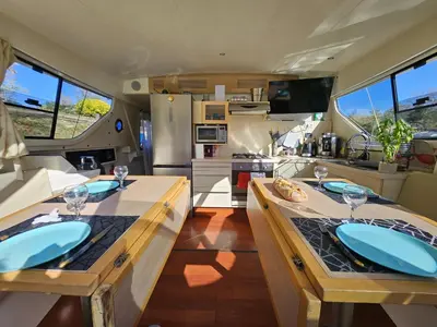 an rv kitchen with two tables with wine glasses at NAVYLIS Croisière in Capestang