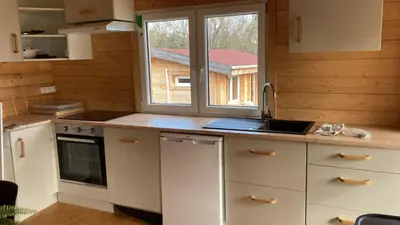 a kitchen with white cabinets and a sink and a window at Au pied du plateau in Campagne-sur-Aude