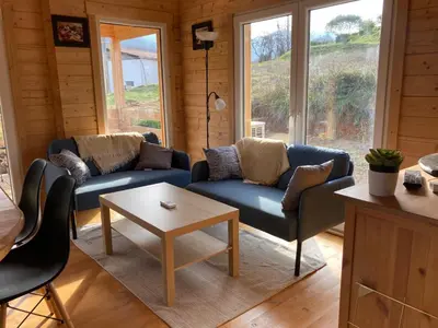 a living room with two blue couches and a table at Au pied du plateau in Campagne-sur-Aude