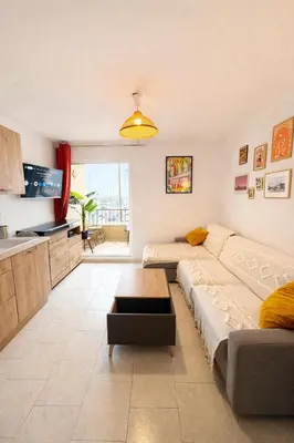 a living room with a bed and a kitchen at NOUVEAU La Grande Voile Piscine-Parking-Draps By LCG in Gruissan