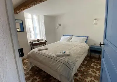 a bedroom with a bed with two towels on it at Maison & Village Quarante - French Village House in Quarante