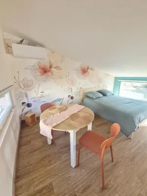 a bedroom with a bed and a table and chairs at Studio cosy in Burlats