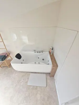 a white bathroom with a bath tub in a room at Studio cosy in Burlats
