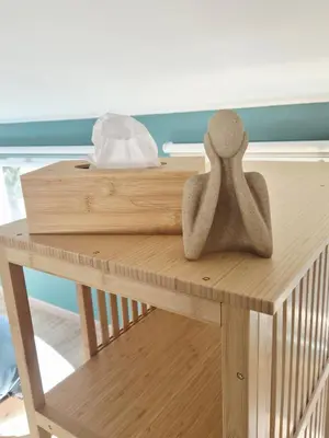 a wooden table with a doll sitting on top of it at Studio cosy in Burlats