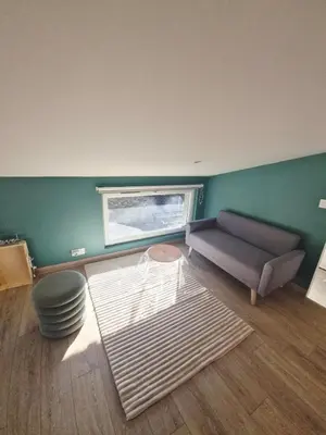 a living room with a couch and a window at Studio cosy in Burlats