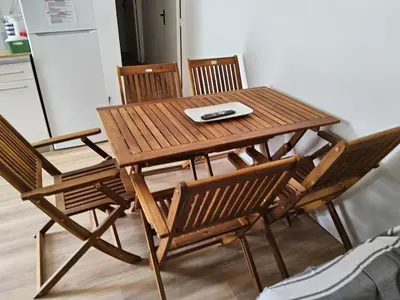 a wooden table with chairs and a remote control on it at Barracuda of port terrace sea for 6 in Port-la-Nouvelle