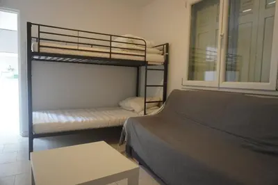 a bedroom with two bunk beds and a table at Le Rouget du Port, Sea Terrace and Air Conditioning in Port-la-Nouvelle