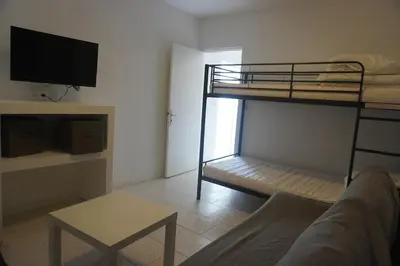 a living room with a bunk bed and a couch at Le Rouget du Port, Sea Terrace and Air Conditioning in Port-la-Nouvelle