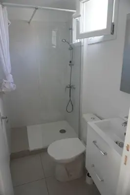 a white bathroom with a toilet and a shower at Le Rouget du Port, Sea Terrace and Air Conditioning in Port-la-Nouvelle