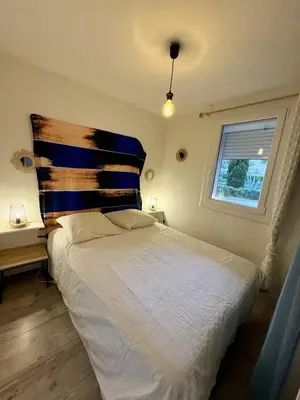a bedroom with a bed with a pillow and a window at Rez-de-jardin moderne - Accès direct plage in Gruissan