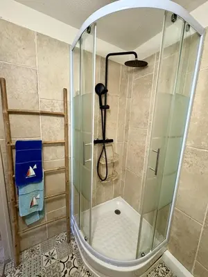 a shower with a glass enclosure in a bathroom at Rez-de-jardin moderne - Accès direct plage in Gruissan