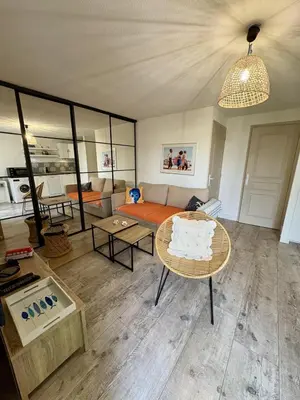 a living room with a couch and a table at Rez-de-jardin moderne - Accès direct plage in Gruissan